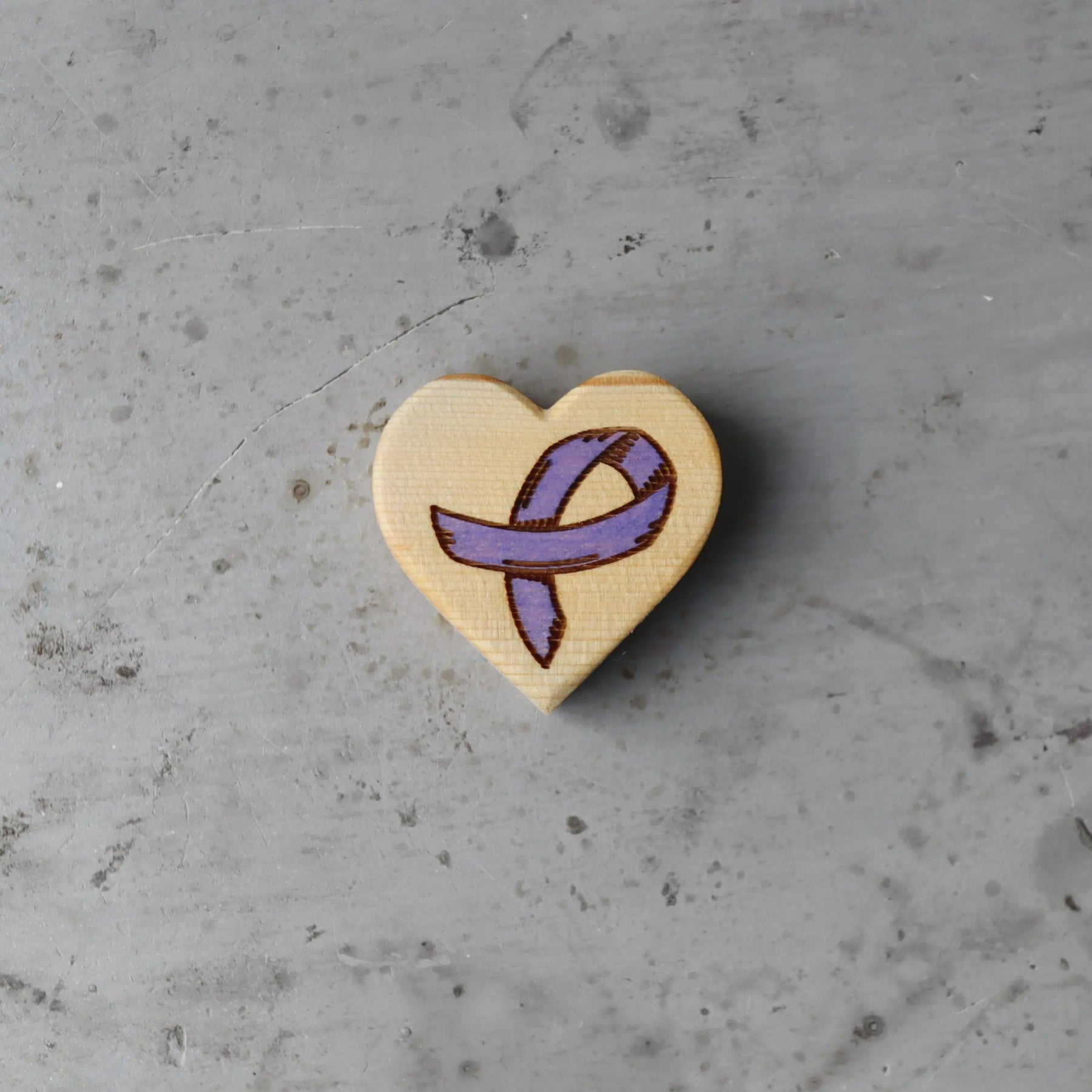 Wooden heart with a purple awareness ribbon engraving.