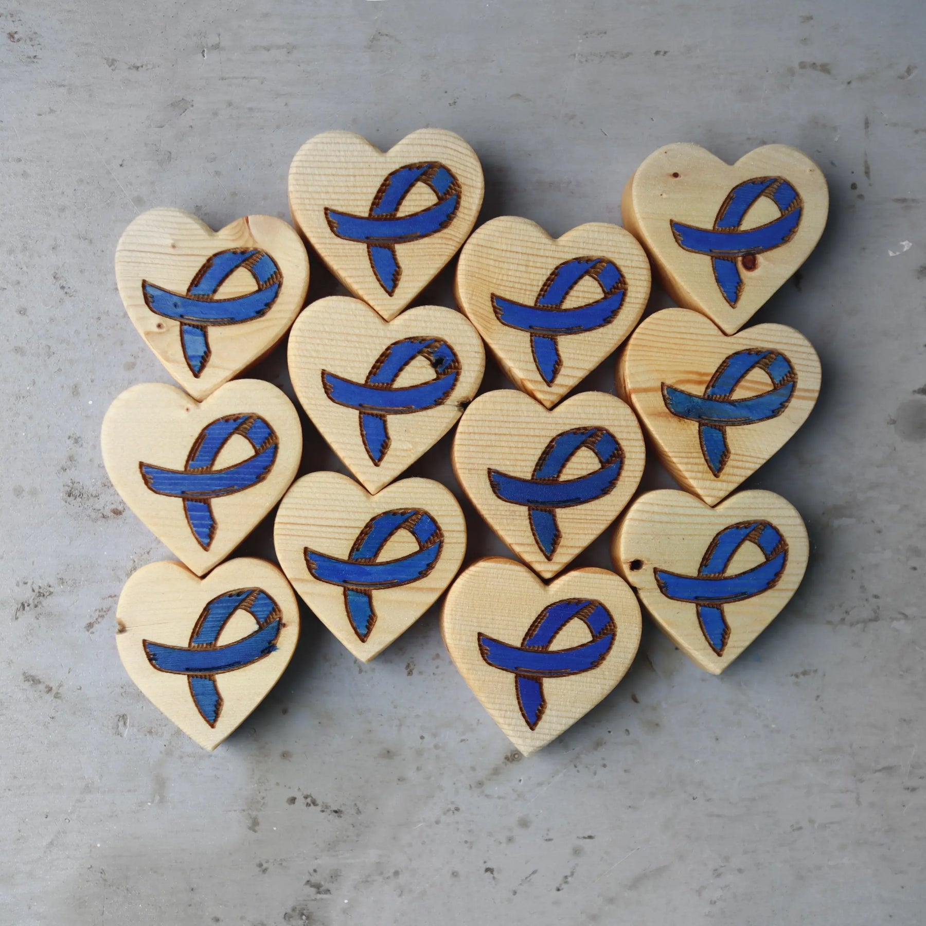 Wooden hearts with blue ribbons for cancer awareness.