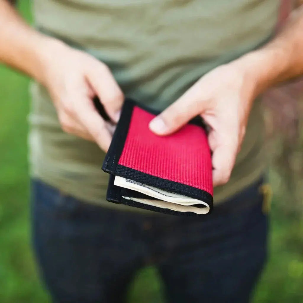 Red bifold wallet being held by hands