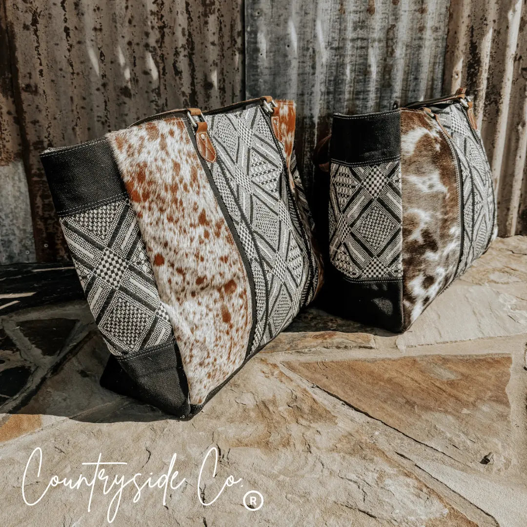 Charlene Cowhide Weekender Bag with brown and white cowhide and black and white textile patterns.