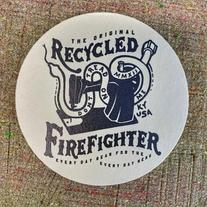 Circular coaster with vintage-inspired "Recycled Firefighter" graphics.