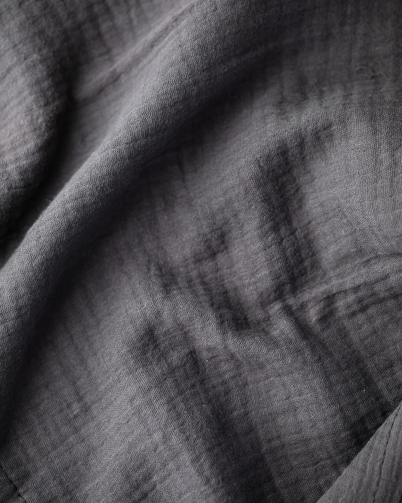 Dark gray textured crinkle cotton fabric close-up.