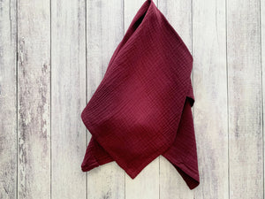 Cotton crinkle cloth napkins, set of four, burgundy color on wood background.