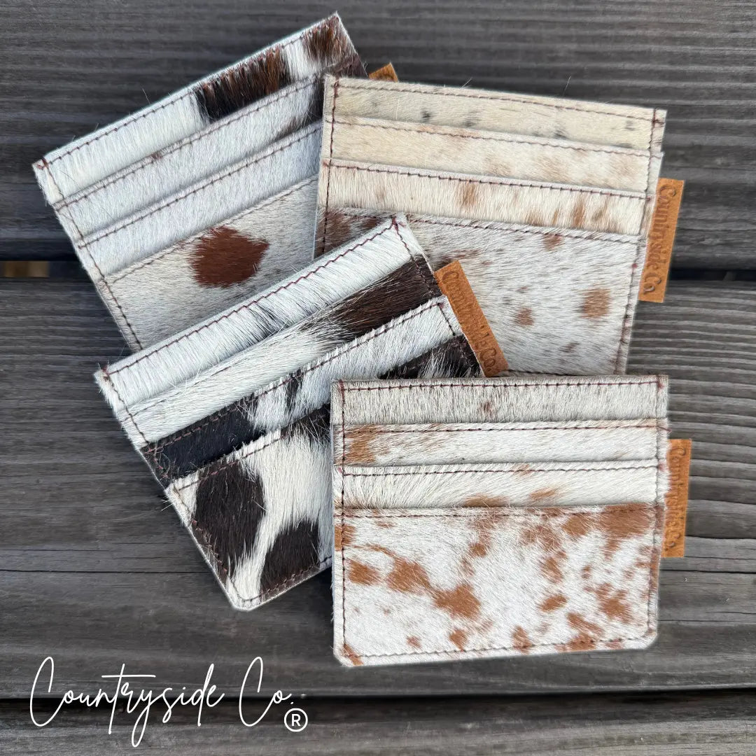 Cowhide credit card holder with multiple slots on a wooden background.