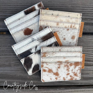 Cowhide credit card holder with multiple slots on a wooden background.