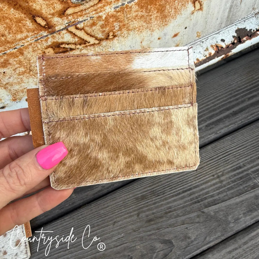 Brown and white cowhide credit card holder with multiple slots, Countryside Co. watermark.
