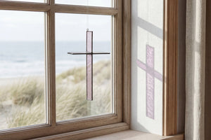 Wheat Mist Cross Suncatcher hanging in a window and catching natural light