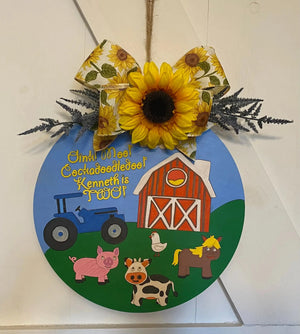 Round wood farm-themed sign with tractor, pig, cow, chicken, and barn, saying "Kenneth is Two!"