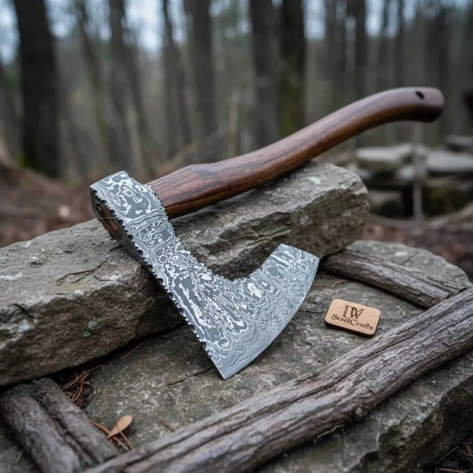 Damascus steel axe head with wood handle on rustic wood surface