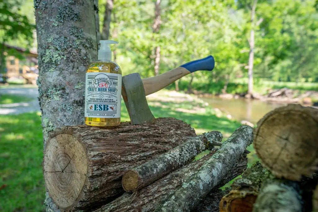 ESB Craft Beer Soap bottle with axe on logs near trees and water
