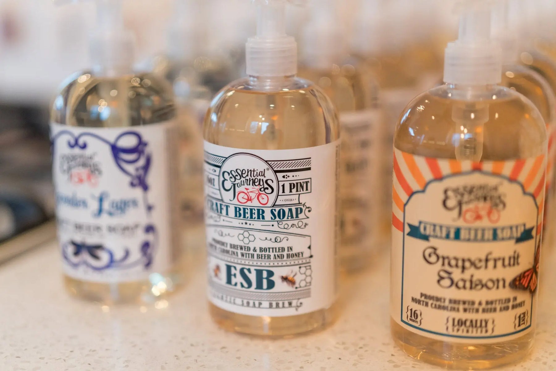 Three bottles of Essential Journeys Craft Beer Soap in ESB and Grapefruit Saison scents.