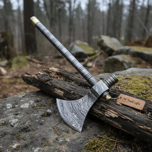 Damascus steel axe head with premium handle on rustic wood surface