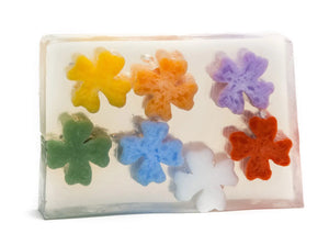 Clear soap bar with colorful flower-shaped embeds in yellow, orange, purple, green, blue, white, and red.