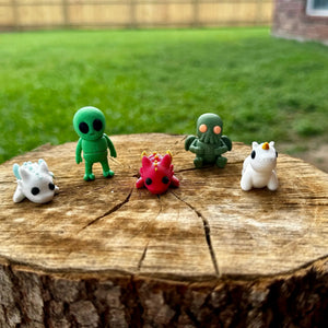 Fantasy Friends Mini Fidget Bundle: 3D printed alien, Cthulhu, dragon, & unicorn toys on tree stump, available at Main Street Collective.