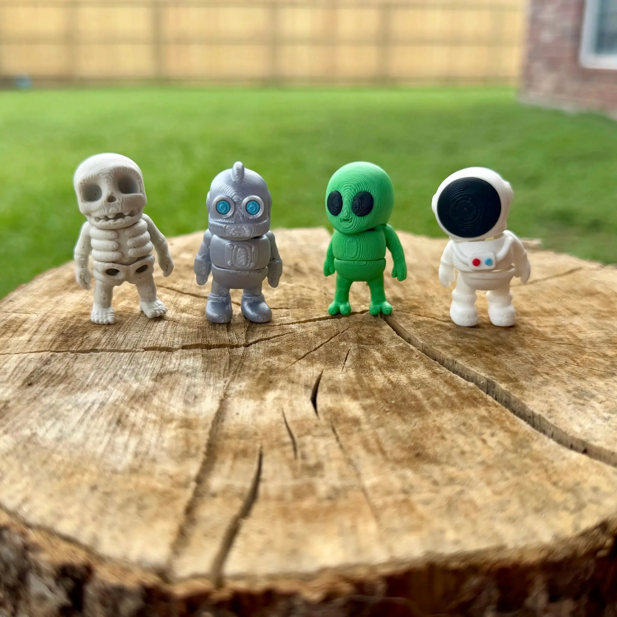 Miniature figurines: Skeleton, Robot, Alien, Astronaut toy set on wood. Fantasy Friends collection.