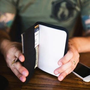 Minimalist black wallet with notebook and cash