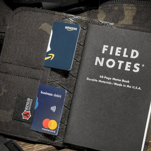 Field Notes wallet with Amazon and Mastercard debit cards, and a black Field Notes notebook.