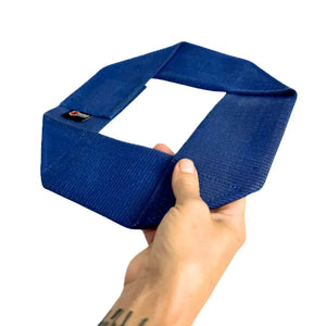 Blue fire hose dog frisbee held by a hand against a white background.