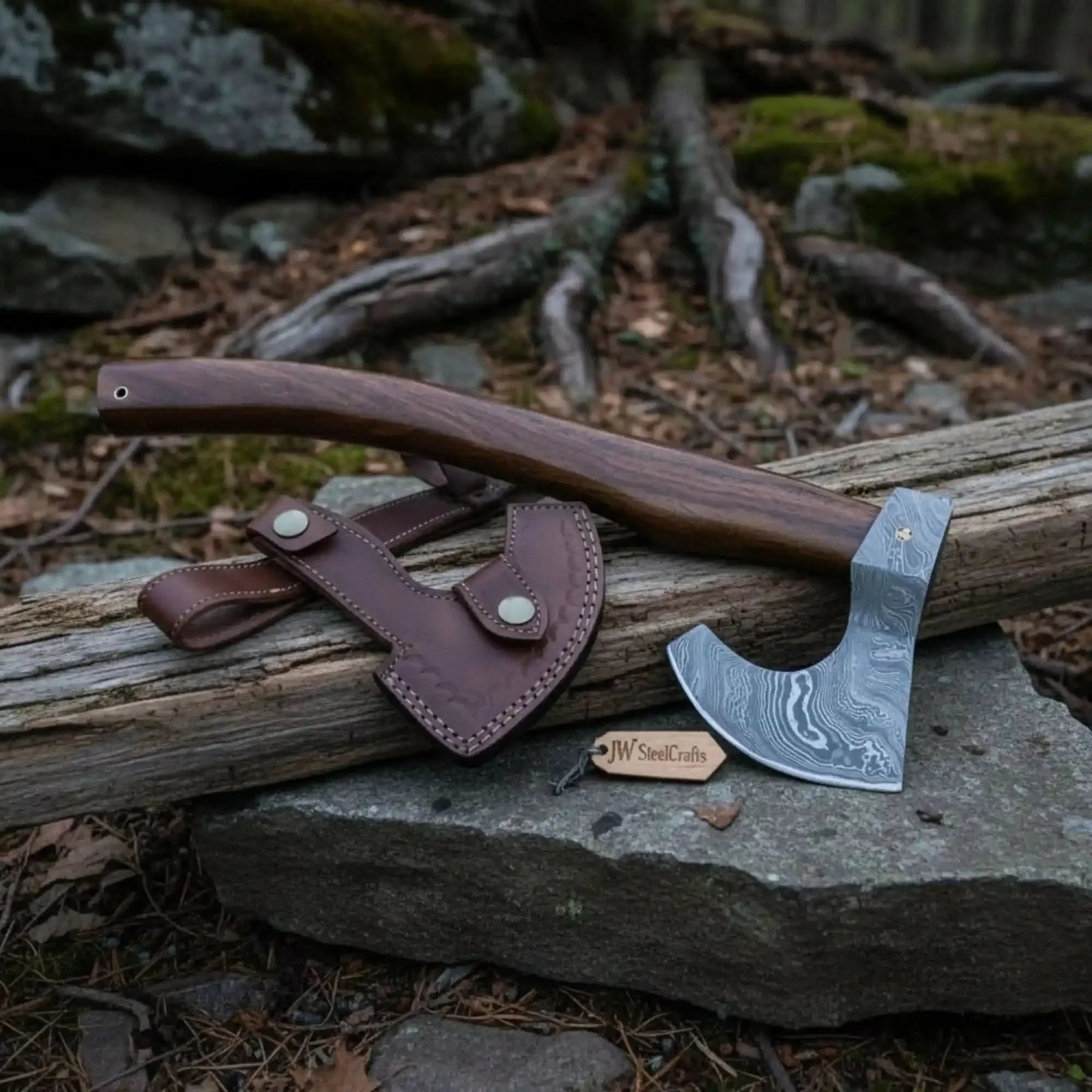 Damascus steel axe head with wood handle on rustic wood surface