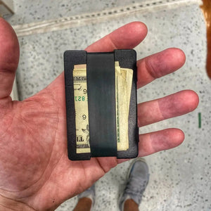 Leather card wallet with silicone cash strap holding bills
