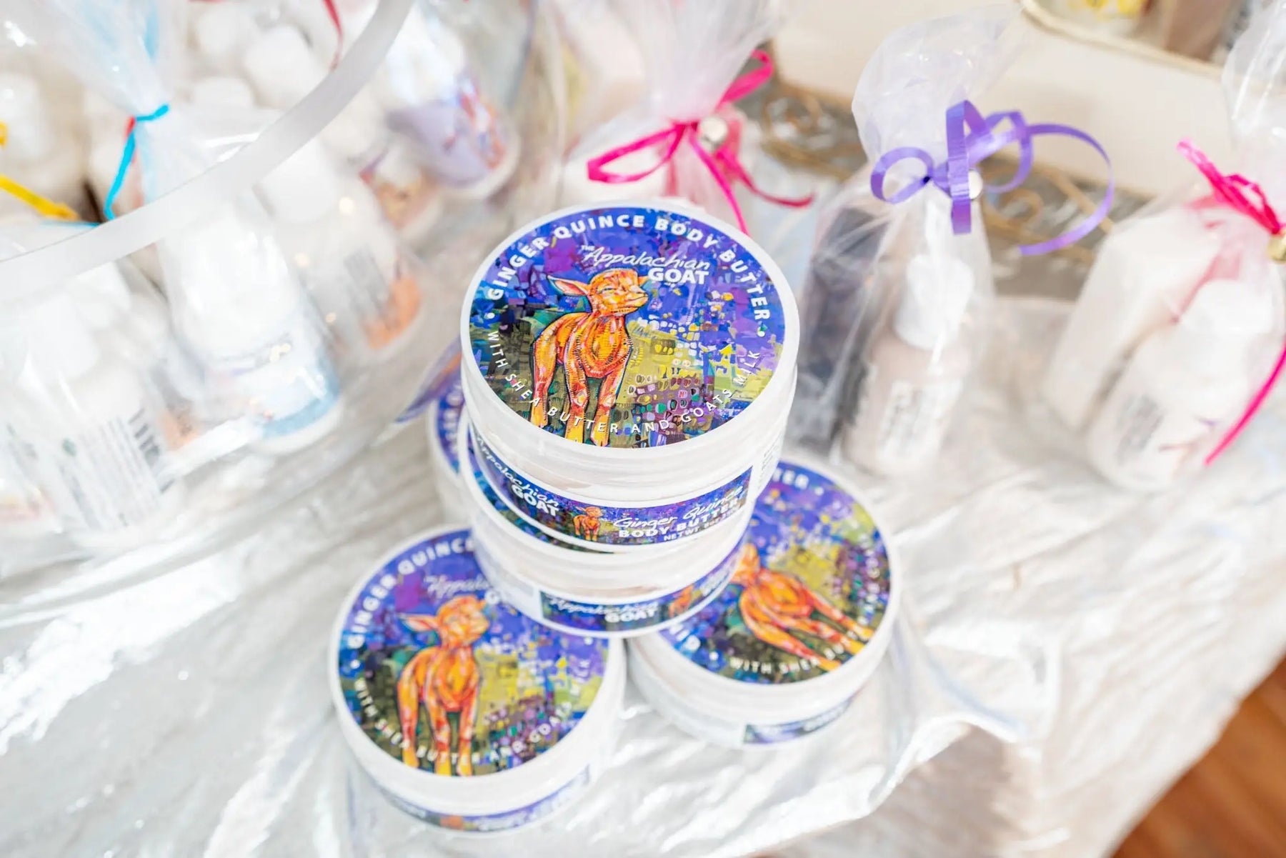 Appalachian Goat Ginger Quince Body Butter tubs stacked and wrapped with ribbons.
