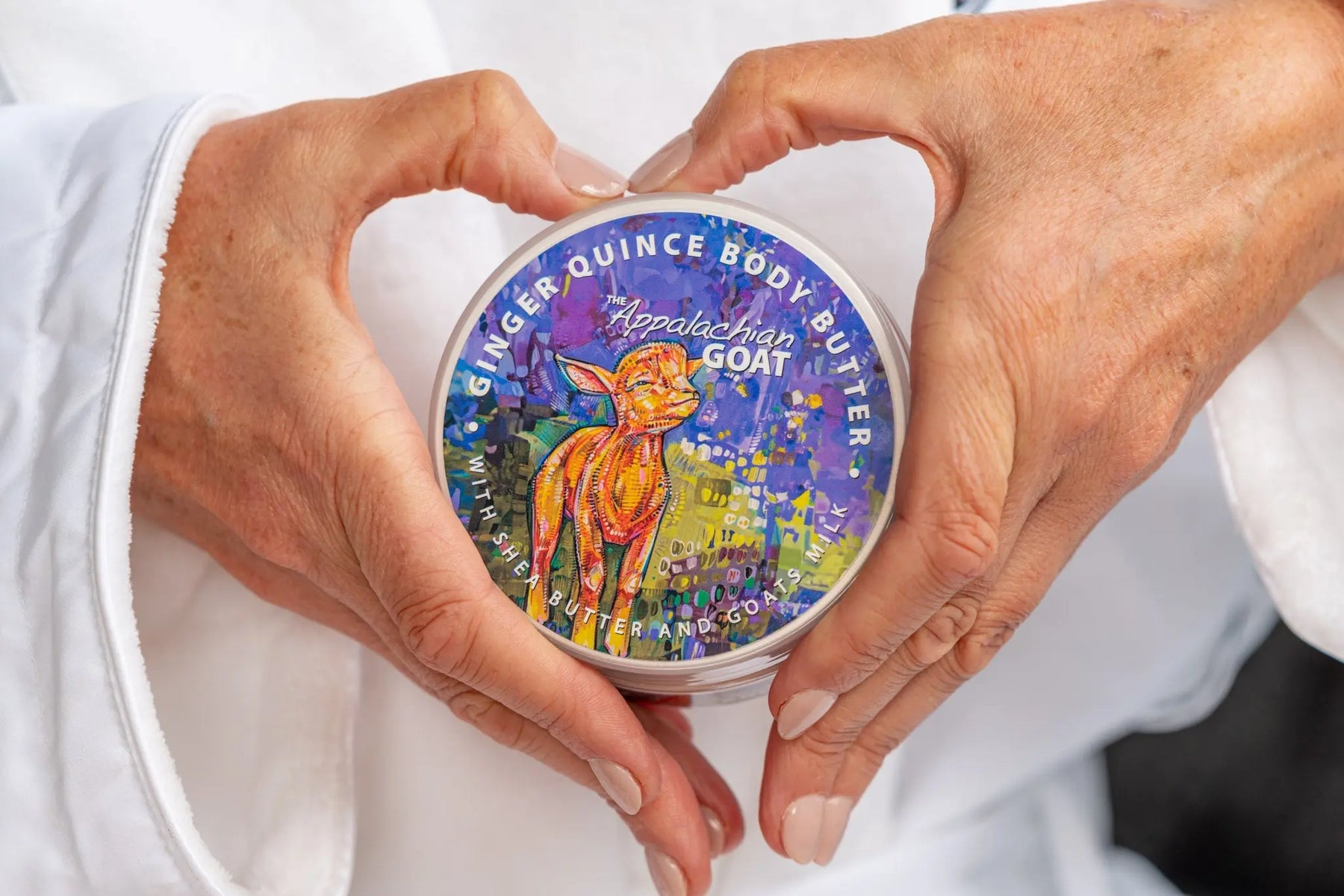 Ginger Quince Body Butter with Goats Milk label held by hands.