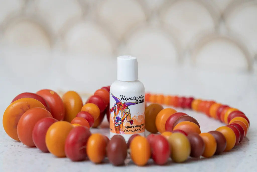 Grapefruit goat's milk lotion bottle surrounded by colorful beads.