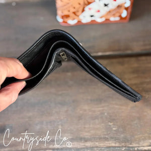 Black leather bifold men's wallet with hand-tooled aces detail.