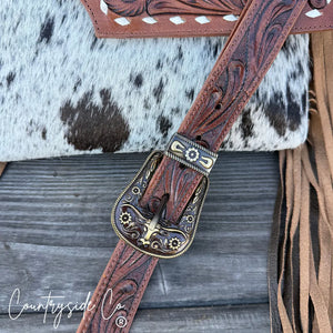 Countryside Co. tooled leather purse strap with ornate buckle and cowhide accent.
