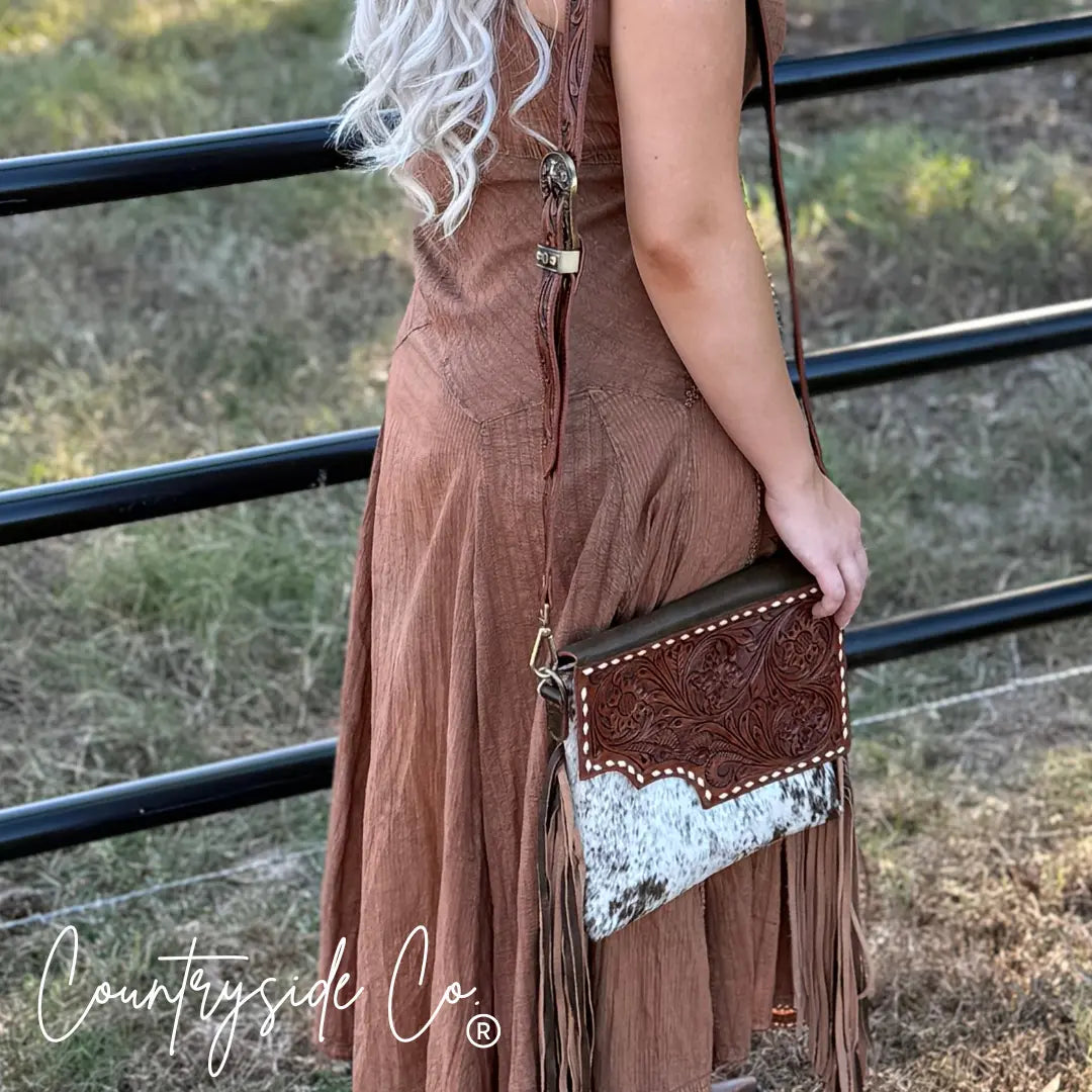 Brown tooled leather crossbody purse with cowhide and fringe details