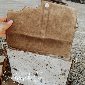 Conceal carry purse with cowhide and tooled leather flap open.