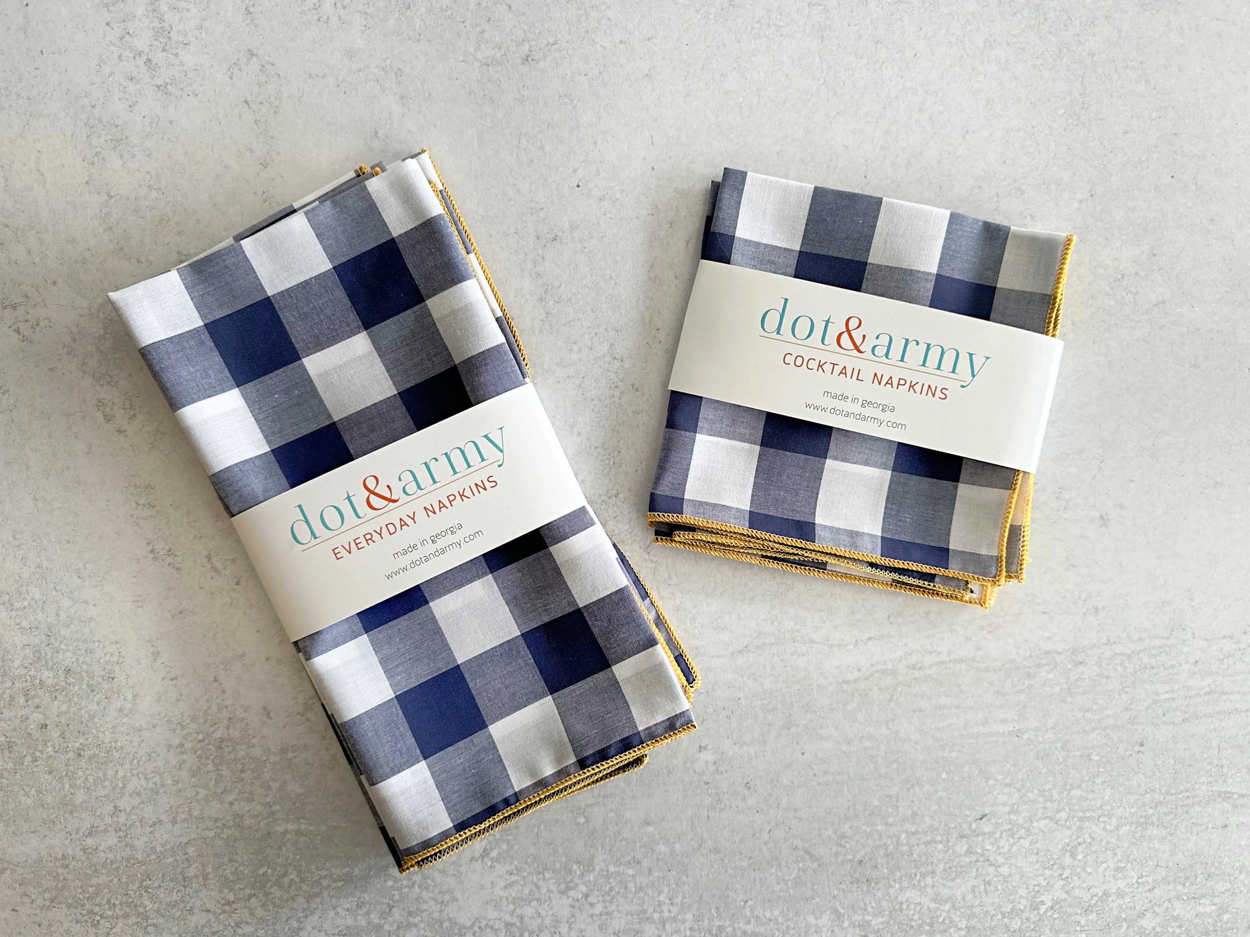 Navy and white gingham cloth napkins with gold trim, one set labeled Everyday, the other Cocktail.