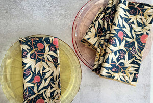 Navy blue floral pattern cloth napkins on yellow and pink glass plates.