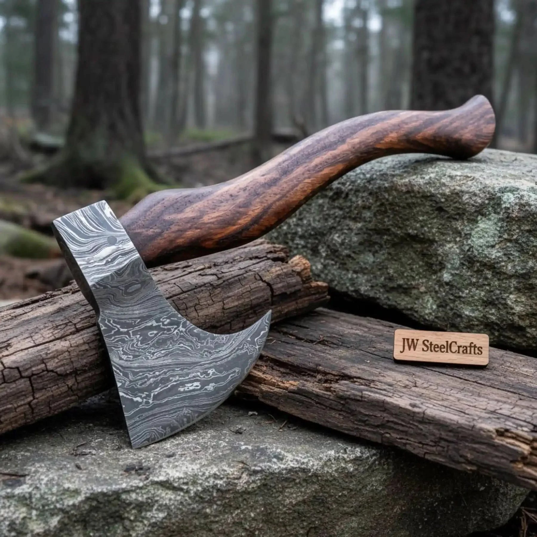 Damascus steel axe head with wood handle on rustic wood surface