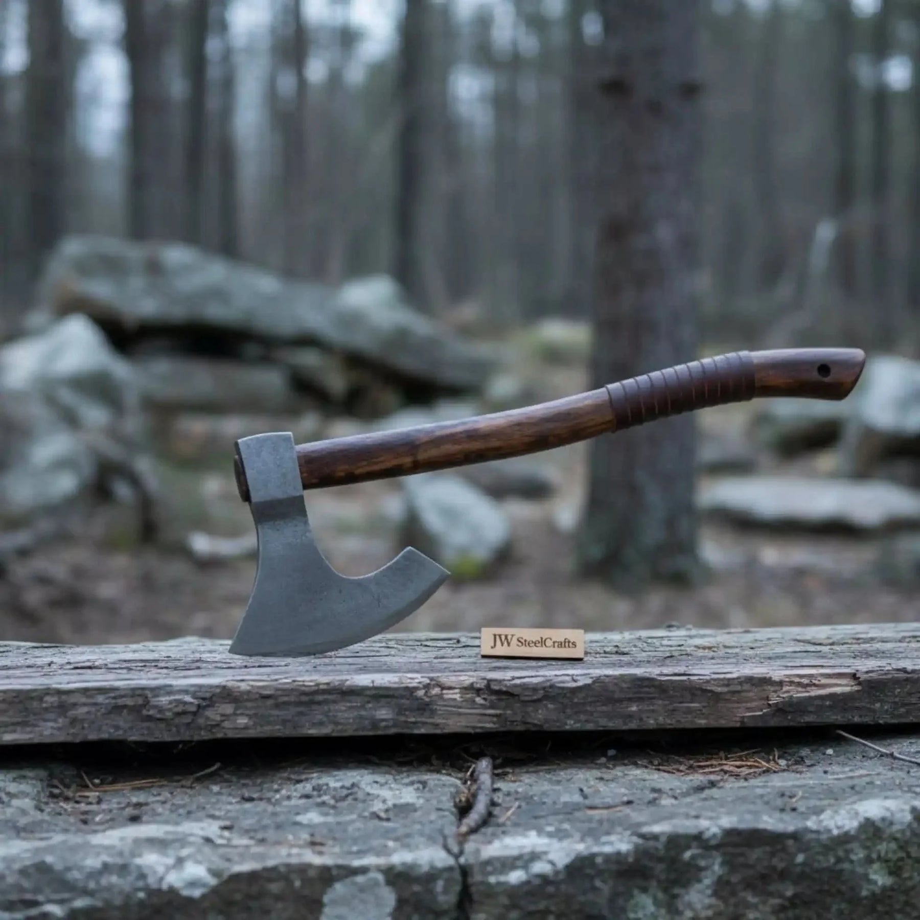 Damascus steel axe head with wood handle on rustic wood surface