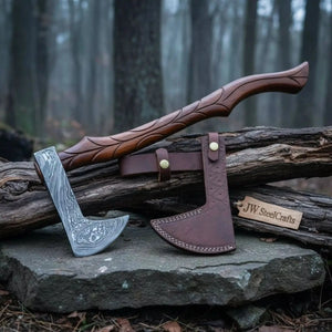 Damascus steel axe head with leather handle on rustic wood surface