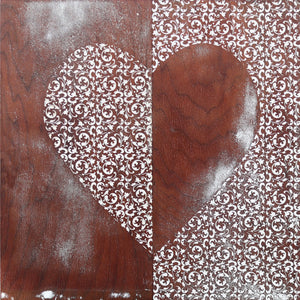 Heart shape with white filigree pattern on wood background