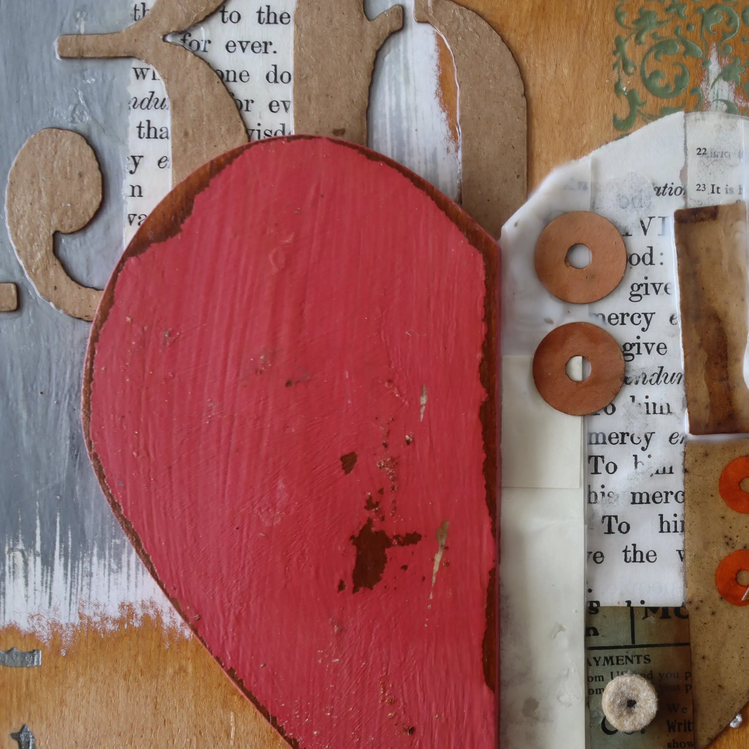 Red heart collage art with text and circular embellishments on textured background.