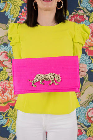 Hot pink clutch with gold leopard embellishment and ruffled sleeve blouse.