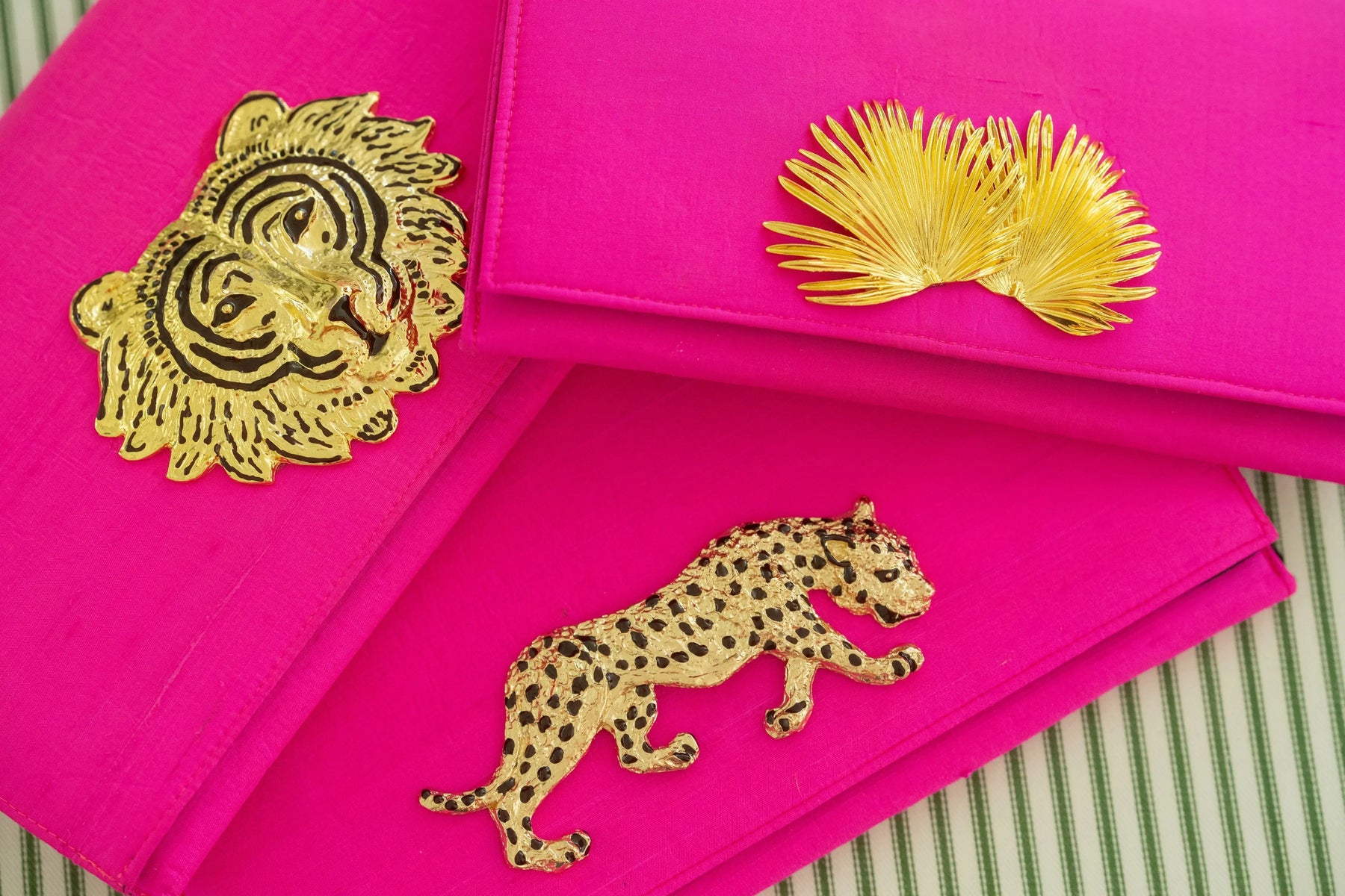 Hot pink clutch with gold tiger and leopard embellishments.
