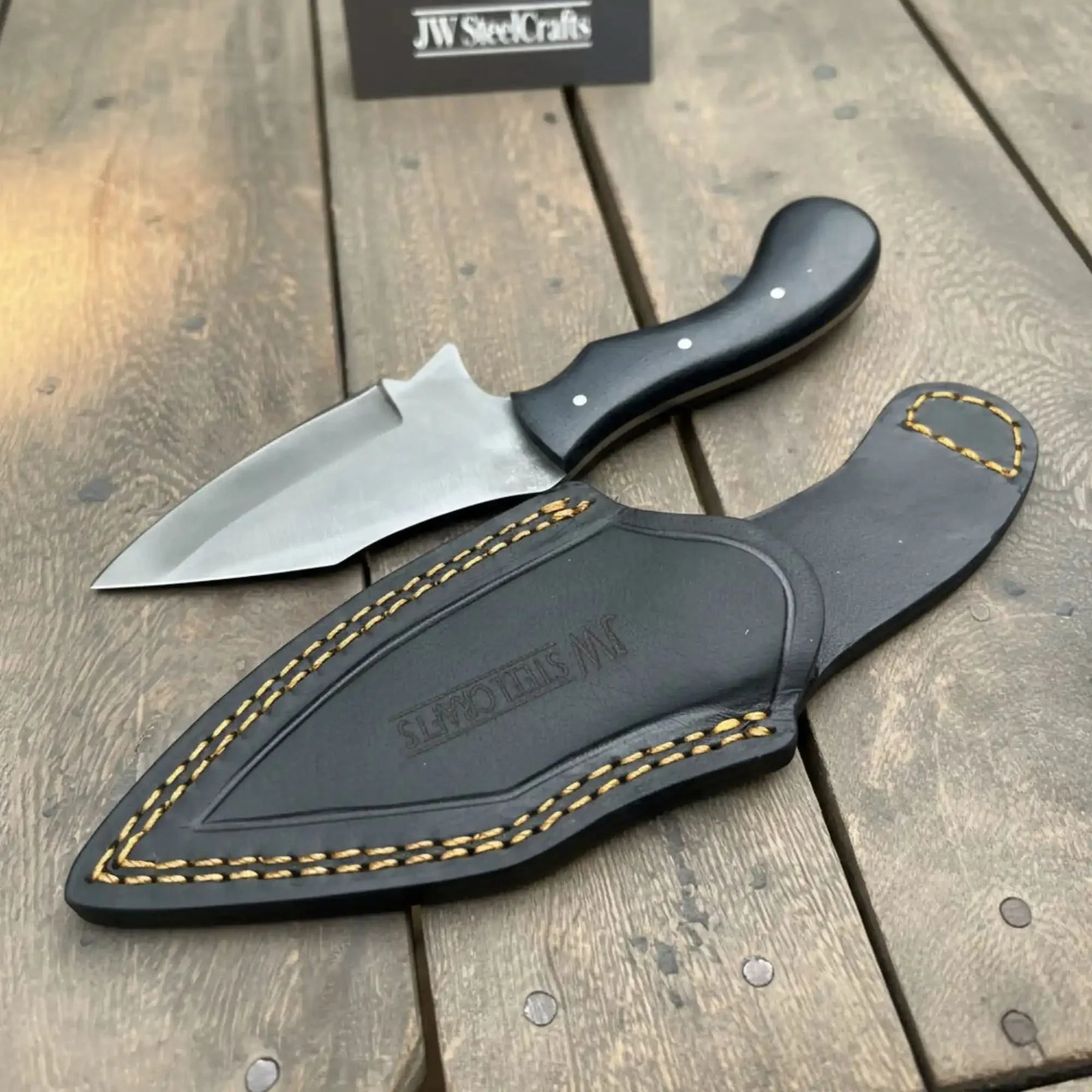 Handmade damascus steel knife with micarta handle on dark surface