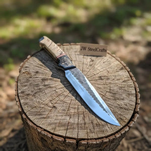 Handmade carbon steel steel knife with horn handle on dark surface