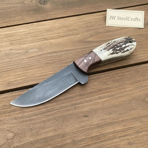 Handmade damascus steel knife with premium handle on dark surface