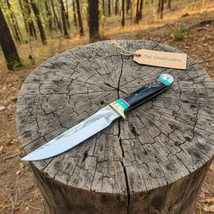 Handmade carbon steel steel knife with horn handle on dark surface