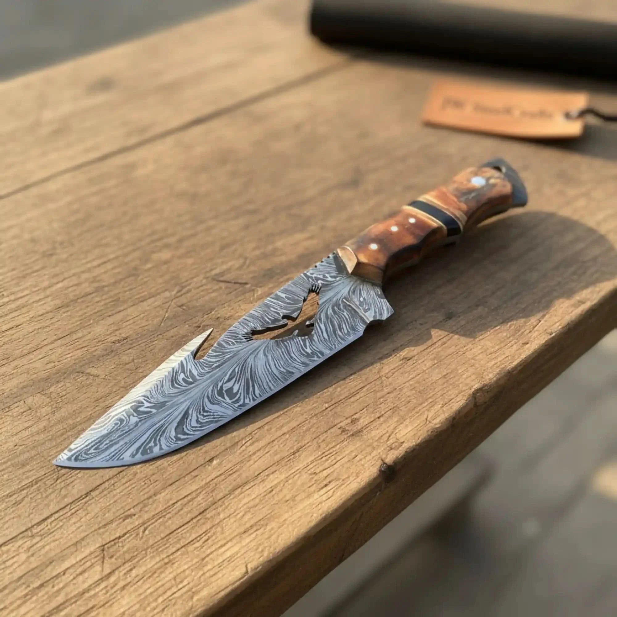 Handmade damascus steel knife with bone handle on dark surface