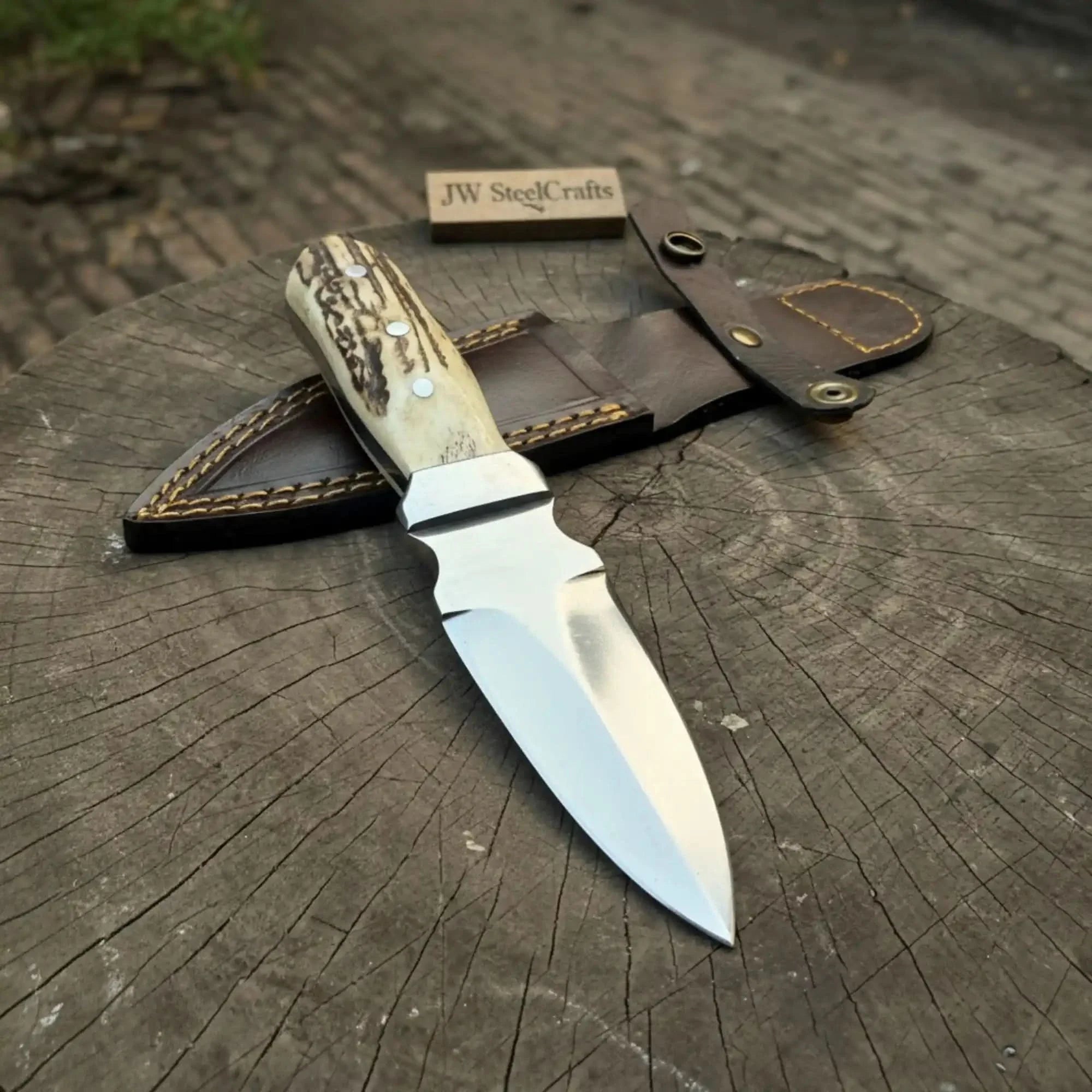 Handmade damascus steel knife with premium handle on dark surface