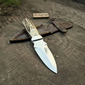 Handmade damascus steel knife with premium handle on dark surface