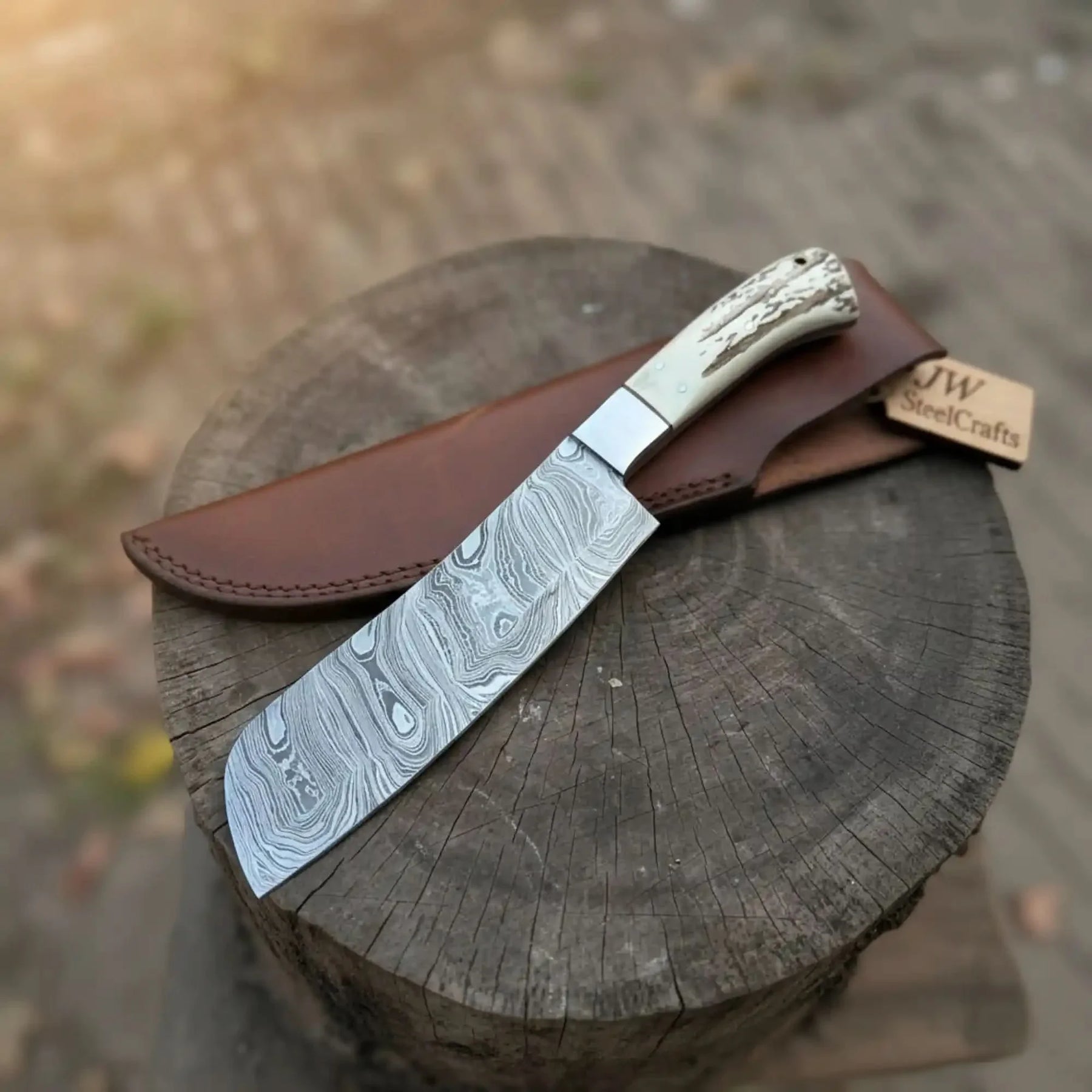 Handmade damascus steel knife with premium handle on dark surface