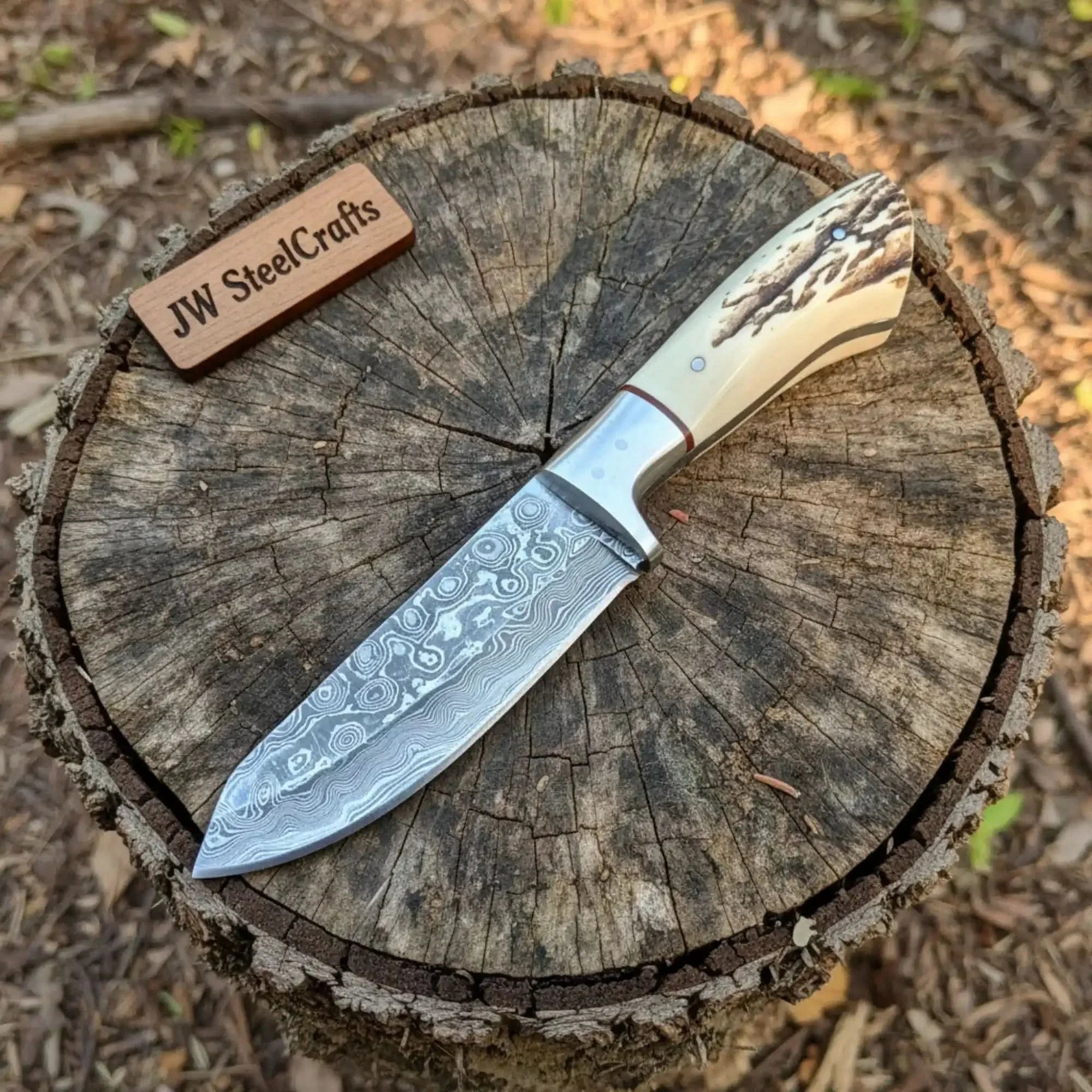 Handmade damascus steel knife with premium handle on dark surface