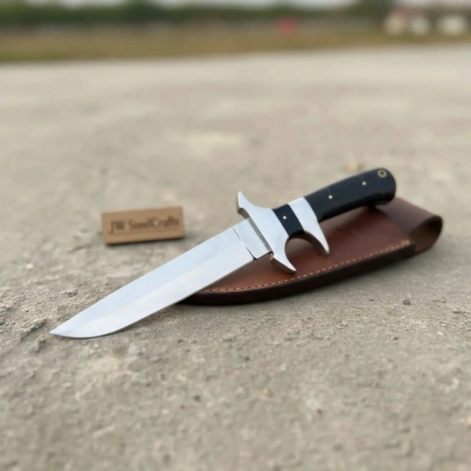 Handmade damascus steel knife with premium handle on dark surface